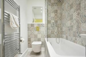 a bathroom with a tub and a toilet and a sink at The Lodge Alnwick in Alnwick +14 photos