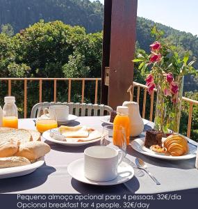 a table topped with plates of food and orange juice at Pera da Serra - Turismo no Espaço Rural in Lousã