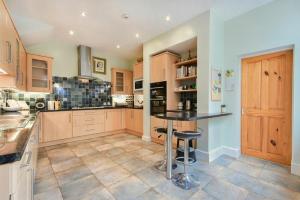 a large kitchen with a table in the middle at The Burgage House in Warkworth