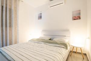 a bed in a white room with a table at Abbas BayView Apartment in Haifa