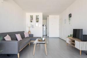 a living room with a gray couch and a coffee table at Abbas BayView Apartment in Haifa