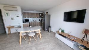 a living room with a table and a kitchen at Résidence Le Bella Vista in Piana