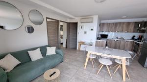 a living room with a green couch and a table at Résidence Le Bella Vista in Piana