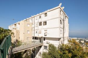 a white building with a balcony on the side of it at Abbas BayView Apartment in Haifa