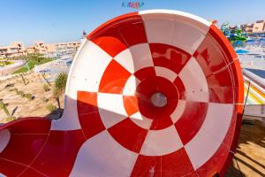 ein rotweißes Objekt mit einem Strand im Hintergrund in der Unterkunft Neverland City Hurghada - Pickalbatros in Hurghada