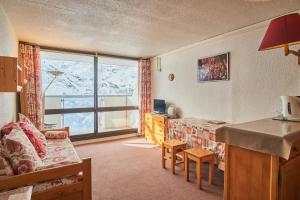 a room with a bed and a desk with a window at Appartement au pied des pistes in Saint-Martin-de-Belleville