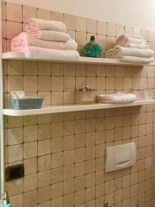 baño con estanterías y toallas en una pared de azulejos en Casa De Pellegrin Bellagio Lake Como, en Bellagio