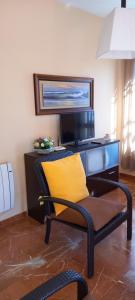 a chair with a yellow pillow in front of a desk at Apartamento Cordobán Centro in Córdoba