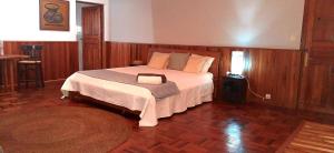 a bedroom with a large bed in a room with wooden floors at L'anis Etoilé in Antsirabe