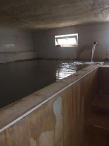 een ondergrondse kamer met een zwembad met water en een raam bij Sivas Sıcak Çermik Kaplıca Villa 