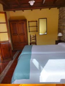 ArgüeroにあるCasa El Prado de la Romiaのベッドルーム1室(ベッド1台、鏡、椅子付)