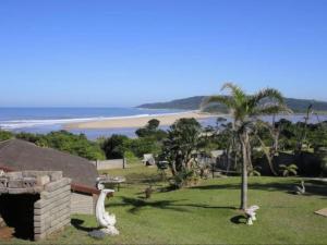 a backyard with a view of the beach and a house at Driftwood Chalets in Tugela Mouth