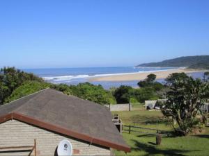 a roof of a building with a beach in the background at Driftwood Chalets in Tugela Mouth