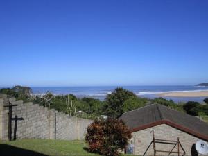 a building with the ocean in the background at Driftwood Chalets in Tugela Mouth