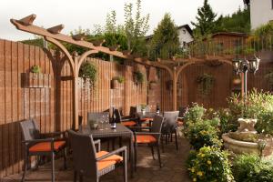 a patio with tables and chairs under a pergola at Weingut Hees - Landgasthof Zum Jäger aus Kurpfalz in Auen