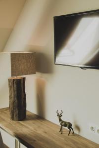 a table with a lamp and a statue of a deer on it at Weingut Hees - Landgasthof Zum Jäger aus Kurpfalz in Auen