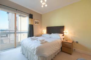 Un dormitorio con una cama grande y una ventana grande. en Castle View at the Viking, en Seahouses