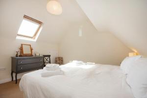 a bedroom with a white bed and a window at The Old Concert Room in Alnmouth