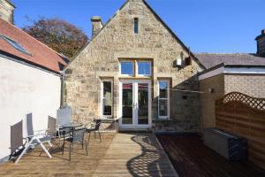 a brick house with a patio with a table and chairs at The Old Concert Room in Alnmouth