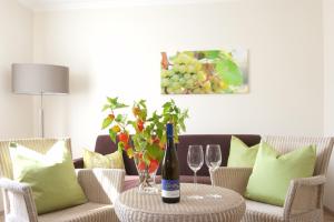 a table with a bottle of wine and two wine glasses at Weingut Hees - Landgasthof Zum Jäger aus Kurpfalz in Auen +17 photos