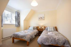 a bedroom with two beds and a window at Castlewood in Bamburgh