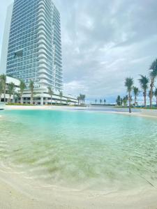 a view of a beach with a tall building at Cozy Studio Unit at Azure North San Fernando Pampanga in San Fernando