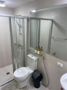 a bathroom with a toilet and a shower and a sink at Cozy Studio Unit at Azure North San Fernando Pampanga in San Fernando