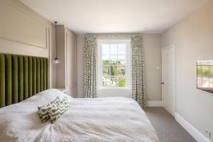 a bedroom with a white bed and a window at Dunsford House - Elegant Townhouse with Parking in Bath