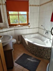 a bathroom with a tub and a toilet and a sink at Ferienwohnung HOAMAT Schmalzreich Andrea in Lam