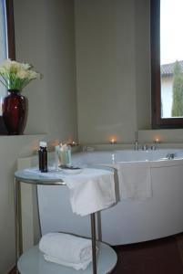 a bathroom with a tub and a table with towels at B&B Villa Natta in Uggiate