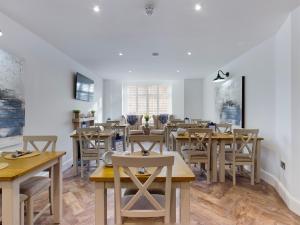 a dining room with wooden tables and chairs at Driftwood Boutique Guest House in Rhosneigr