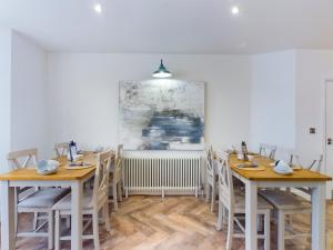 a dining room with wooden tables and chairs at Driftwood Boutique Guest House in Rhosneigr