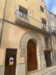 a building with a wooden door and a balcony at Casa Rural Les Caixes in Sant Mateu