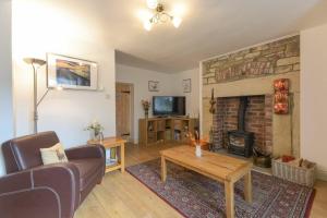 a living room with a couch and a fireplace at Middlemoor Cottage in Alnwick