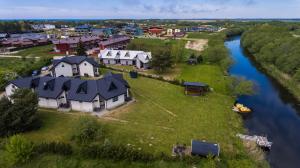 eine Luftansicht eines Dorfes neben einem Fluss in der Unterkunft Apartamentai Upė in Šventoji