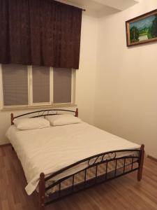 a bedroom with a bed with white sheets and a window at Colour in Baku