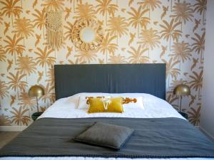 een slaapkamer met een groot bed met gele kussens en behang bij La Source - gîte en Drôme provençale - Allan in Allan