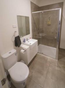 a bathroom with a toilet and a shower and a sink at Modern air-conditioned 3-bedroom townhouse in centre of Cape Woolamai in Cape Woolamai