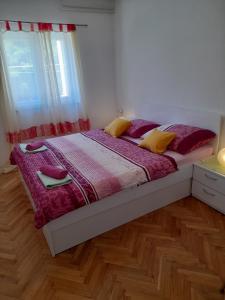1 dormitorio con 1 cama con almohadas moradas y amarillas en Room in Lopar with terrace, air conditioning, WiFi 3719-4 en Lopar