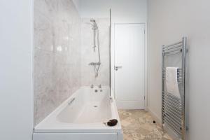 a white bathroom with a tub and a shower at Bluebell Lodge, 29 Roadford Lake Lodges in Lifton +23 photos