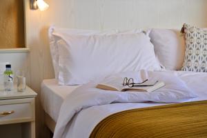 un lit avec un livre et une paire de lunettes dans l'établissement Hôtel Du Golfe, à Ajaccio