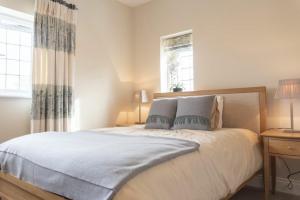 een slaapkamer met een bed met 2 kussens en een raam bij Keeper's View in Bamburgh