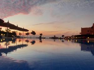 une piscine avec vue sur le coucher du soleil en arrière-plan dans l'établissement La Hacienda - Ras Sedr Chalet - Ras Sudr, à Ras Sudr