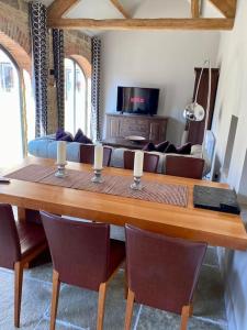 a living room with a table with chairs and a couch at Contemporary Luxury Barn Conversion in County Durham in Durham