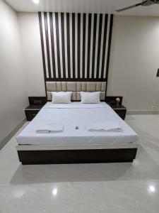 a bedroom with a large bed with a wooden headboard at The Golden Sand in Jamshedpur