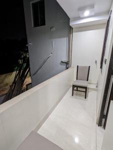 biały korytarz z krzesłem w pokoju w obiekcie The Golden Sand w mieście Jamshedpur