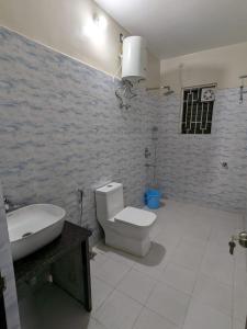 a bathroom with a white toilet and a sink at The Golden Sand in Jamshedpur