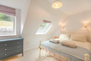a bedroom with a bed with a blue dresser and a window at Partan Cottage in Burnmouth