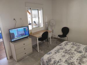 a bedroom with a bed and a desk with a television at Casita La Gomera in San Sebastián de la Gomera