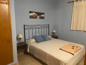 a bedroom with a bed with blue pillows on it at Casa Rural Les Caixes in Sant Mateu